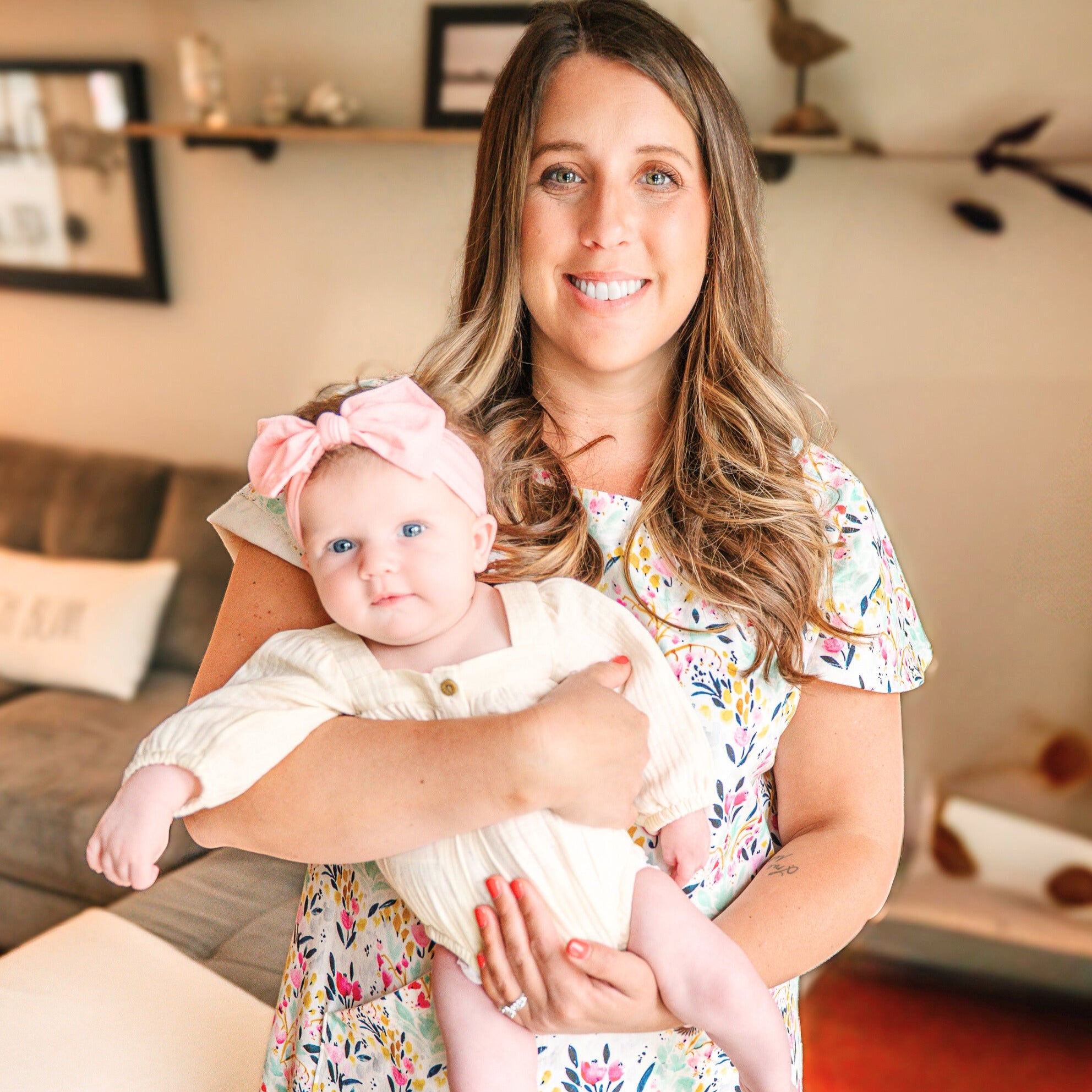 Woman holding a baby in a living room setting