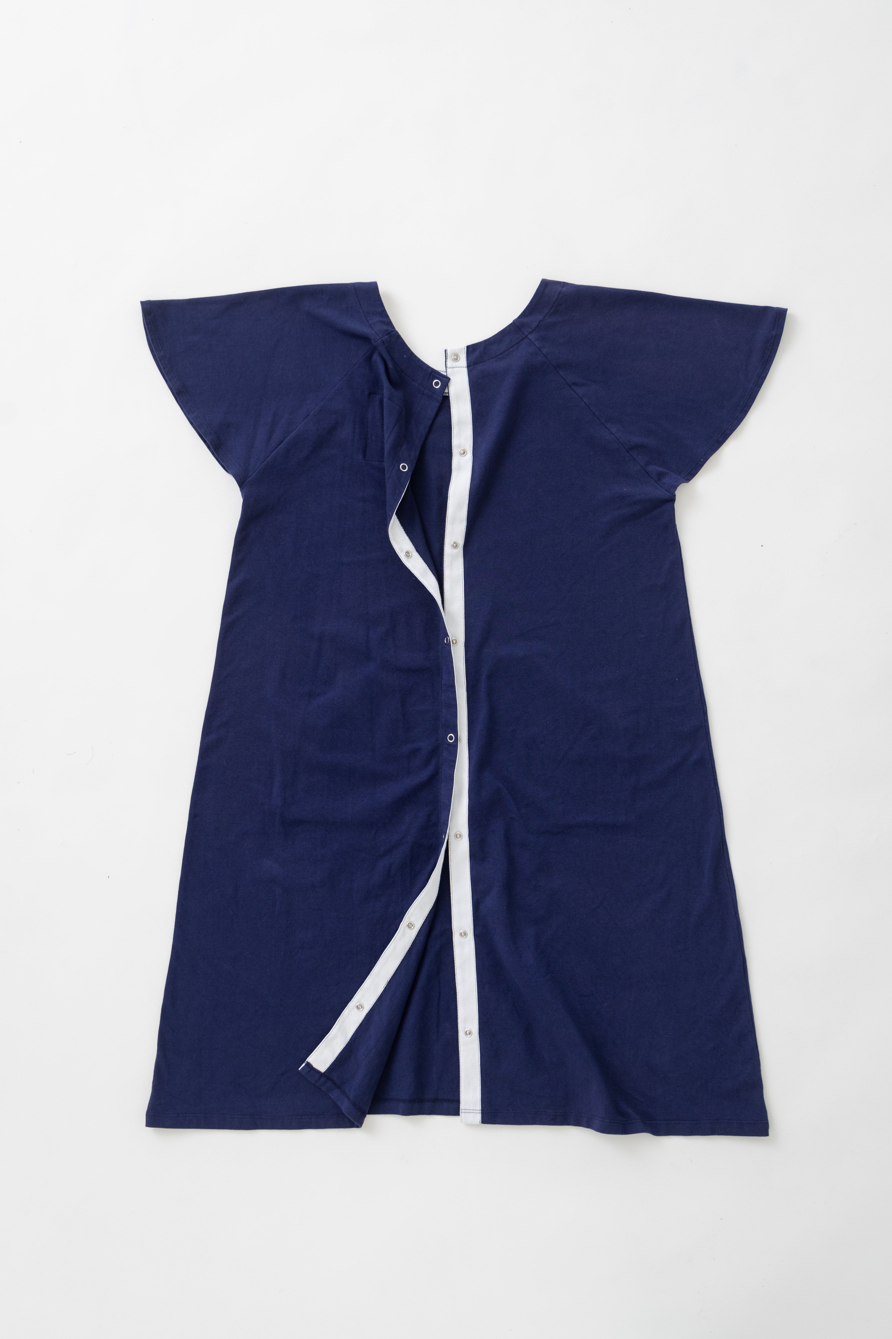 Flat lay of blue hospital gown, backside, showing snaps