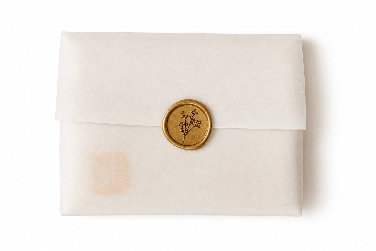 A cream-colored envelope with a gold wax seal featuring a botanical design, set against a plain white background.