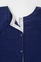 Close up image of backside of navy hospital gown showing snaps