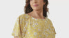 Woman wearing Untethered RN-designed patient gown during hospital recovery, organic cotton, full coverage